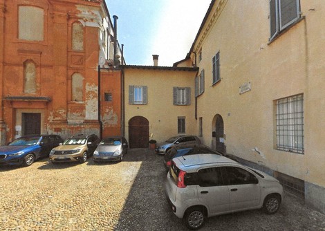 Pietra d'inciampo a Zampieri, simbolo della memoria e della storia locale. Area con auto in sosta.