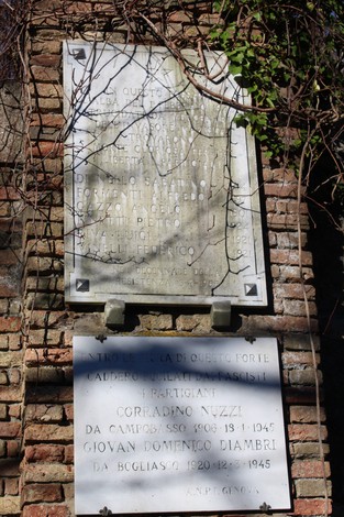 Lapide commemorativa dedicata ai partigiani fucilati al Forte Castellaccio, con iscrizioni storiche e decorative.