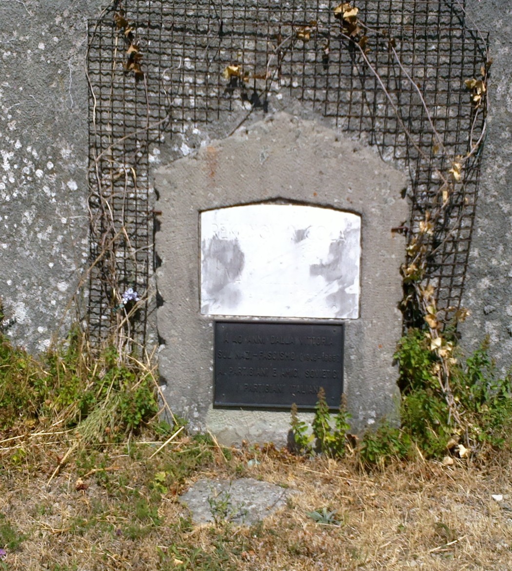 Lapide commemorativa dedicata a Rekunov e Ivan, posizionata in un'area erbosa con vegetazione circostante.