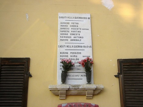 Lapide commemorativa ai caduti di Bornasco nelle guerre 1915-18 e 1940-45, con fiori in ricordo.