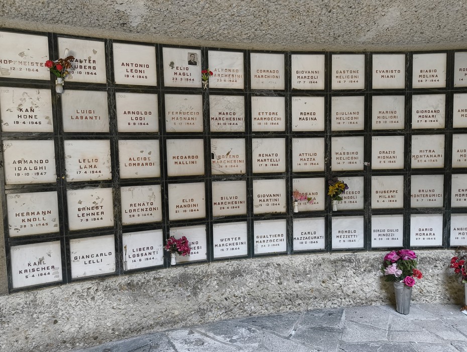 Monumento Ossario dedicato ai caduti partigiani, con lapidi commemorative e fiori.
