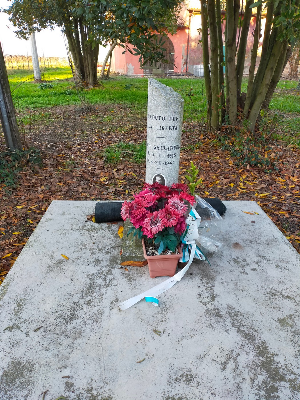 Cippo commemorativo dedicato a Ghirardelli, con fiori e tributi per la libertà.