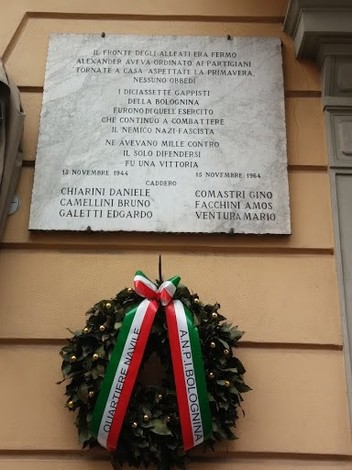 Lapide commemorativa ai Caduti della battaglia della Bolognina, con decorazioni tricolori.