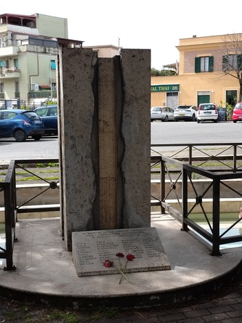 Monumento ai caduti per la libertà di Centocelle, un'imponente struttura commemorativa con fiori ai suoi piedi.
