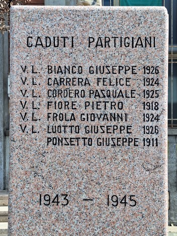 Monumento ai caduti con nomi incisi su una stele commemorativa in marmo, dedicato ai partigiani.