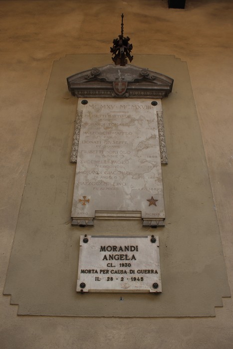 Lapide commemorativa di Angela Morandi, con simboli e iscrizioni in memoria della sua morte durante la guerra.