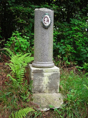 Cippo commemorativo dedicato a Giovanni Ferrioli, immerso nella natura circostante.