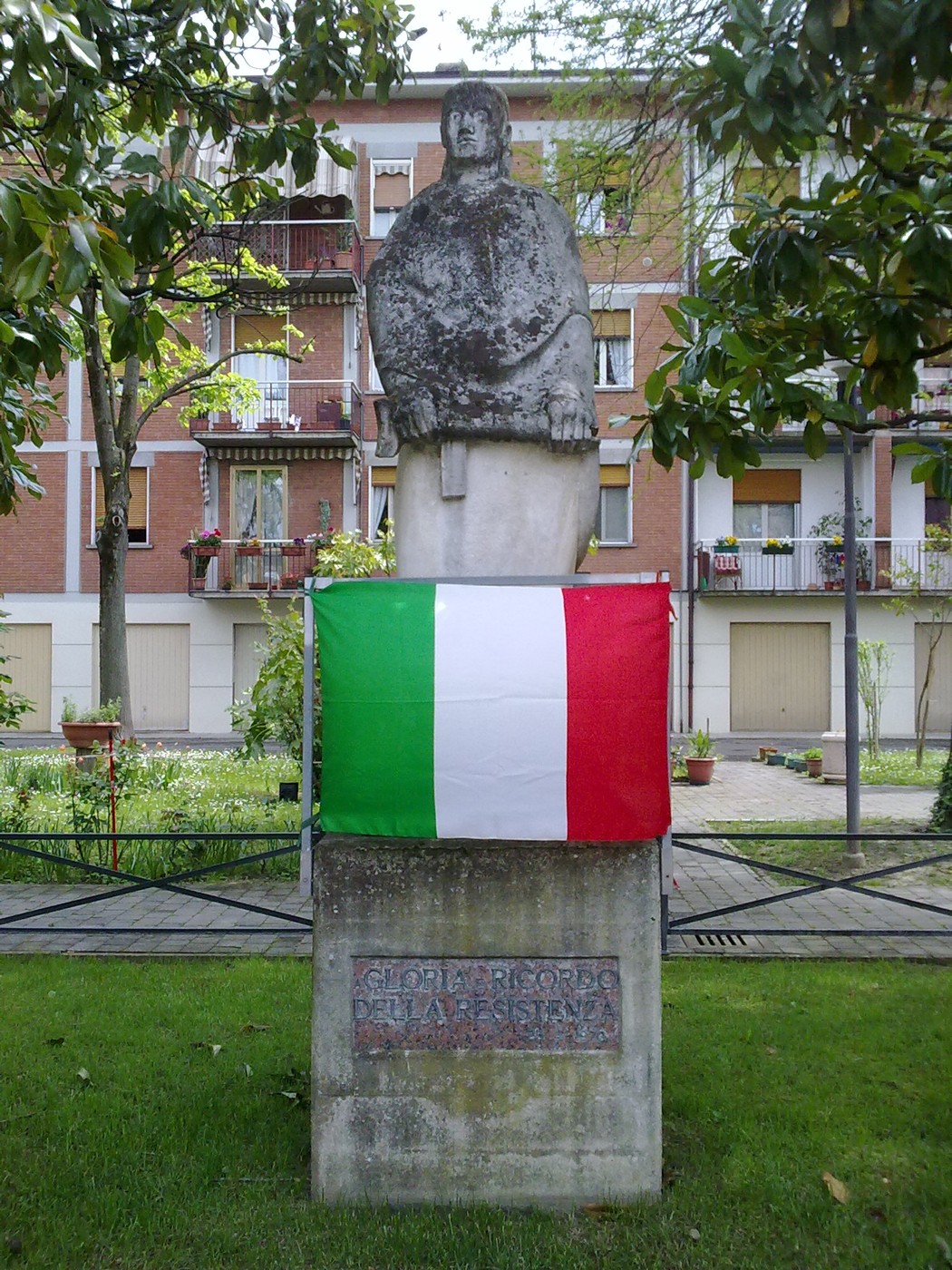 Monumento alla Resistenza, omaggio ai valori di libertà e giustizia, incorniciato da un tricolore italiano.