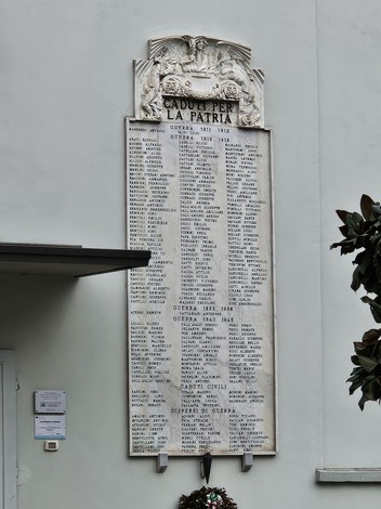 Lapide commemorativa ai caduti di Sorbolo, con nomi incisi e decorazioni ornamentali, apposta su una parete.