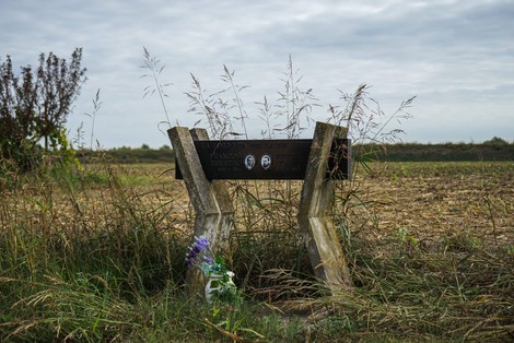 Monumento commemorativo a Franciosi e Vecchi, circondato da vegetazione in un'area rurale.