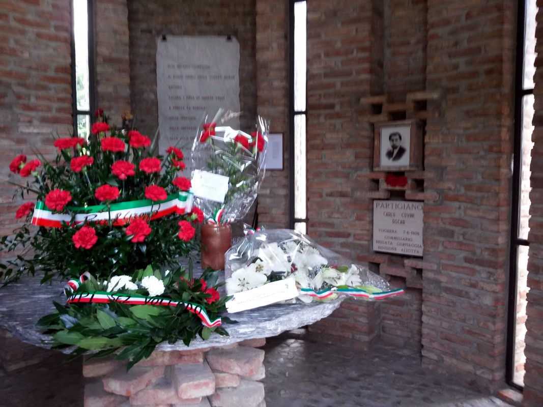 Sacrario Partigiano di Biagasco con fiori e riconoscimenti per i caduti della Resistenza.