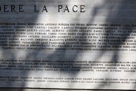 Monumento ai Caduti, con iscrizioni commemorative su una parete di marmo, in un ambiente sereno e riflessivo.