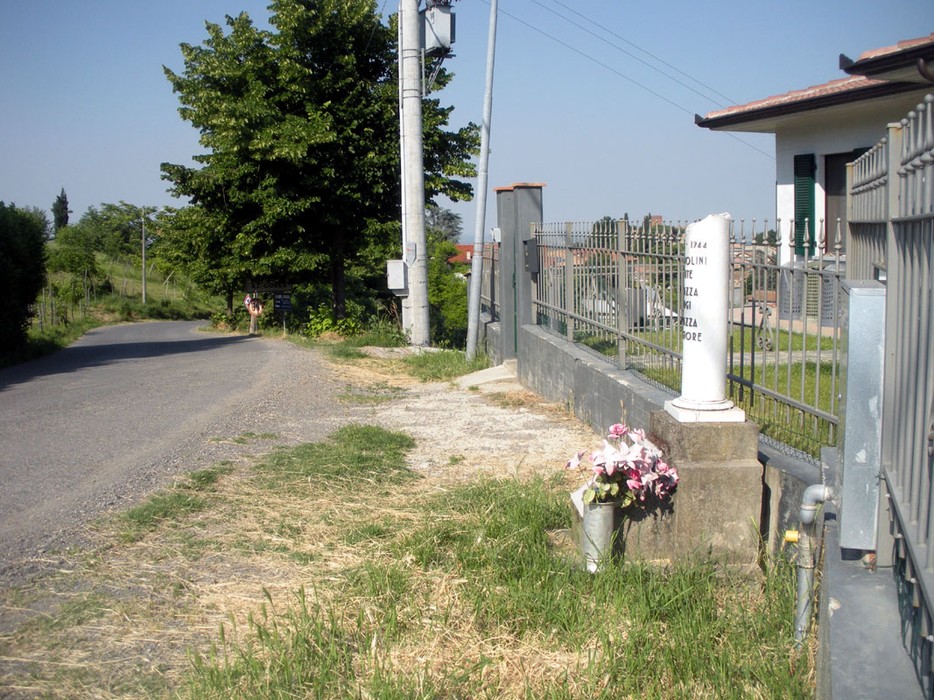 Cippo commemorativo dedicato a Brandolini e ai Fugazza, situato lungo una strada rurale.