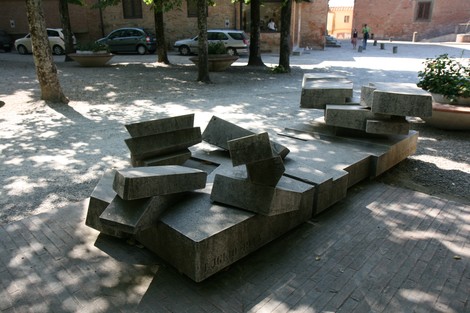 Monumento commemorativo dedicato alle vittime del Duomo, realizzato con blocchi di pietra in un ambiente tranquillo.