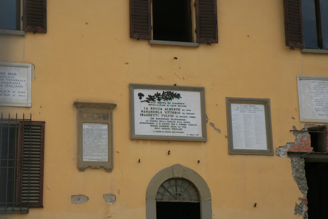 Lapide commemorativa sul municipio, dedicata a eventi storici locali. Mura con affreschi e documenti storici.