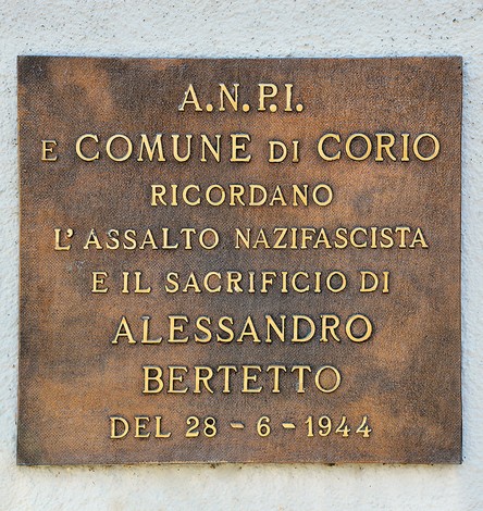 Targa in bronzo su parete chiara, con iscrizione dedicata ad Alessandro Bertetto.