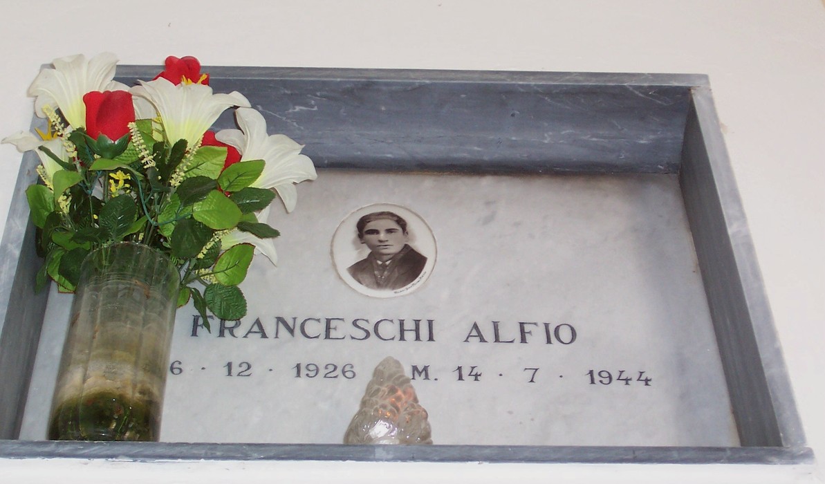 Cappella dei Caduti Partigiani, commemorazione con fiori e un ritratto in memoria dei martiri della Resistenza.