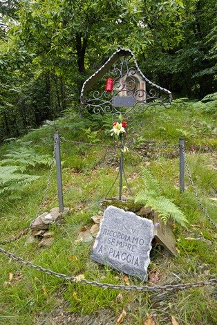 Croce a Salada e Violi, con fiori e commemorazione in un'area boschiva tranquilla.