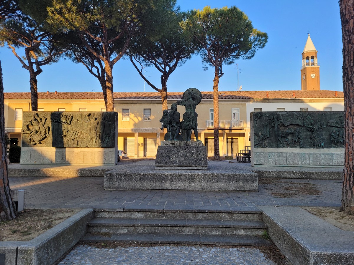 Monumento alla Resistenza, simbolo di libertà e memoria storica, circondato da alberi e un paesaggio urbano.