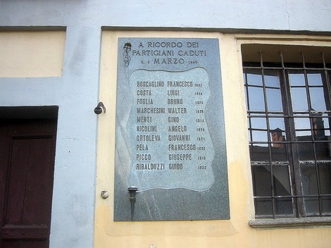 Lapide commemorativa in onore dei partigiani caduti, con nomi e date incisi nella pietra.