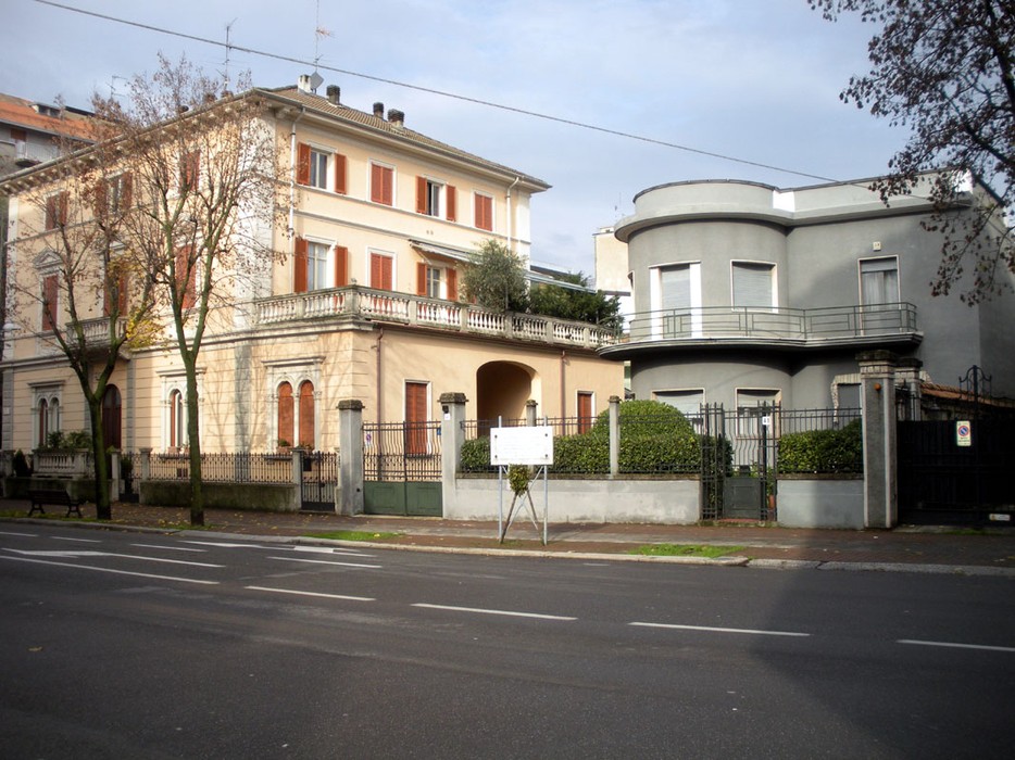 Lapide commemorativa a Tarabella su un edificio storico in una strada di città.
