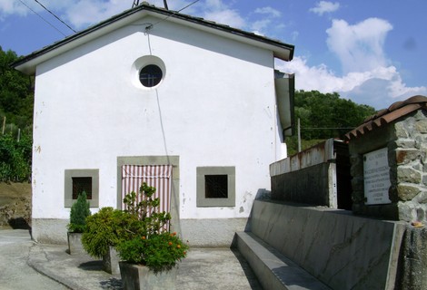 Lapide che ricorda Folegnani, situata presso una piccola chiesa bianca con giardino.