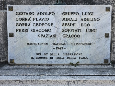 Monumento ai Caduti con nomi incisi in marmo, dedicato alla memoria delle vittime dei campi di concentramento.