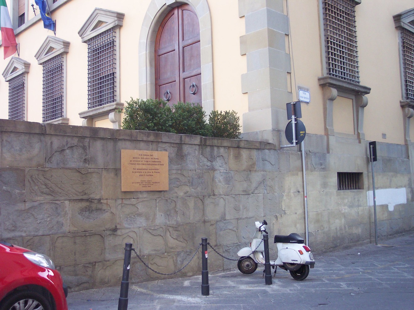 Lapide commemorativa dedicata ai Volontari della Libertà, situata su un muro in una strada urbana.