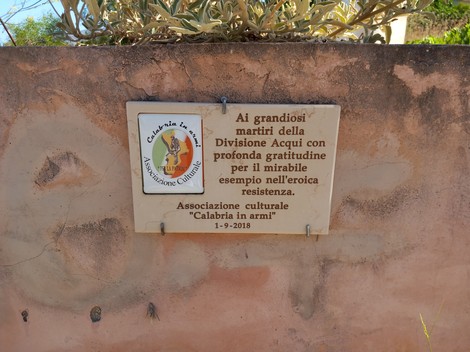 Lapide commemorativa dedicata ai martiri della Divisione Acqui, con messaggio di gratitudine per la resistenza.