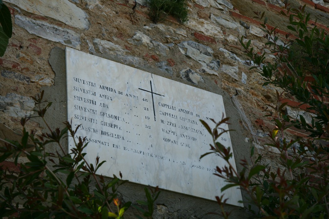 Lapide commemorativa sulla facciata della Casa Silvestri, decorata con una croce e nomi di familiari.