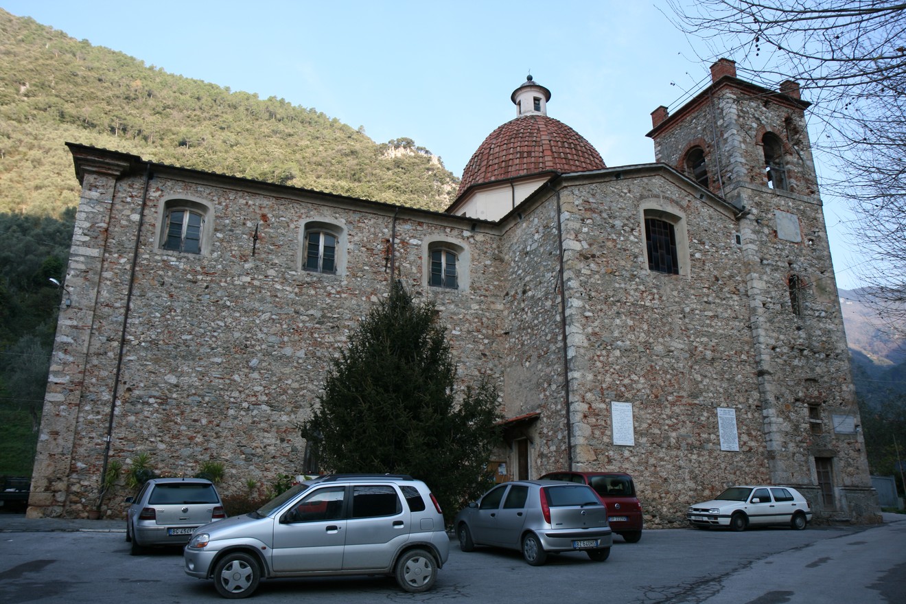 Chiesa di Valdicastello, caratterizzata da una struttura in pietra e circondata da natura.