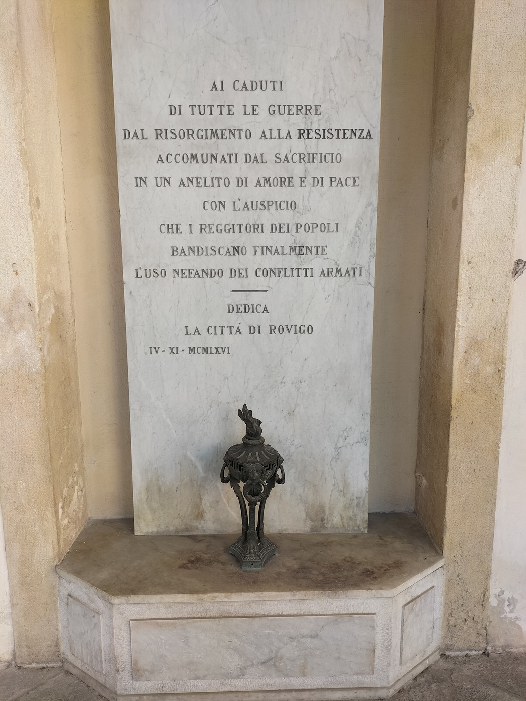 Lapide commemorativa dedicata alla pace, situata in un angolo di un edificio storico.