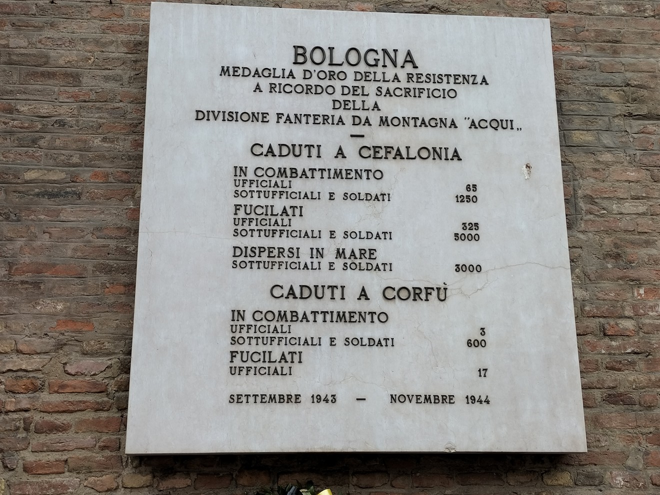 Lapide commemorativa dedicata ai caduti della divisione "Acqui" durante la resistenza a Bologna.