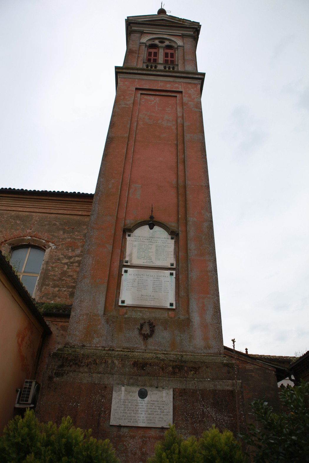 Lapide commemorativa ai caduti di Calamosco, situata su un alto edificio rustico.