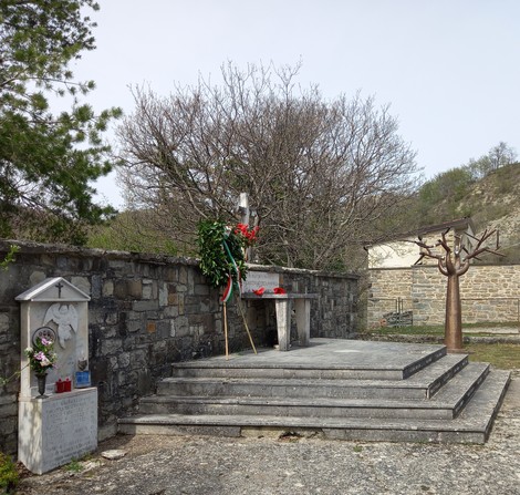 Cenotafio in memoria delle vittime di Fragheto, circondato da una vegetazione e un paesaggio sereno.
