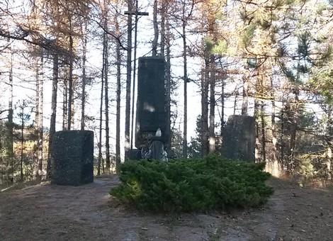 Monumento di Casa Piazza circondato da alberi, un luogo di memoria immerso nella natura.