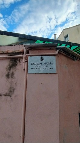 Lapide commemorativa di Bruzzone Andrea, eroe della Resistenza, collocata su un muro colorato.