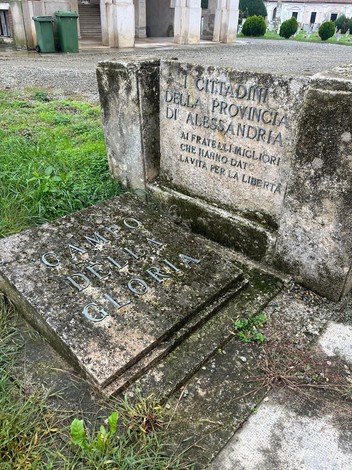 Targa commemorativa "Campo della Gloria" con iscrizioni su pietra in un'area verde.