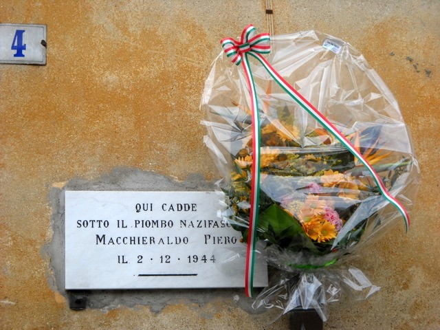 Lapide commemorativa a Macchieraldo in memoria delle vittime del nazifascismo. Fiori e decorazioni tricolori.