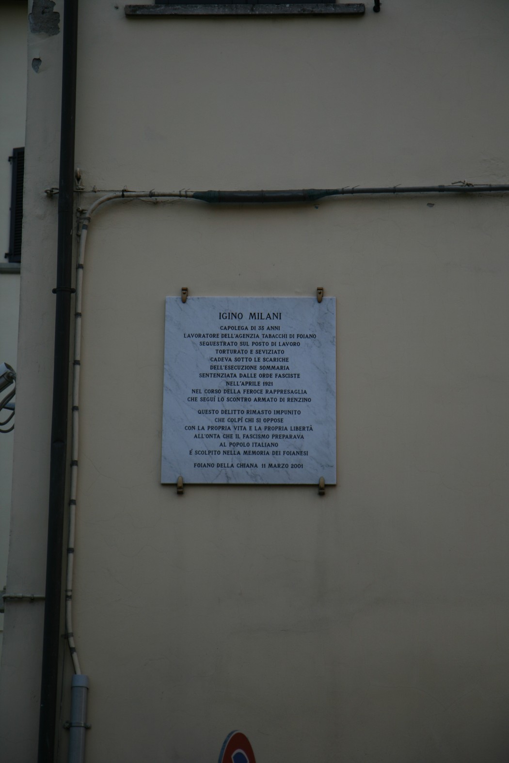 Lapide commemorativa dedicata a Igino Milani, con testo in memoria della sua vita e opere.