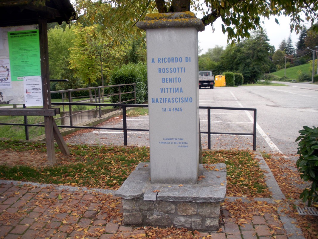 Cippo commemorativo dedicato a Benito Rossotti, vittima del nazifascismo, situato in un'area verde.