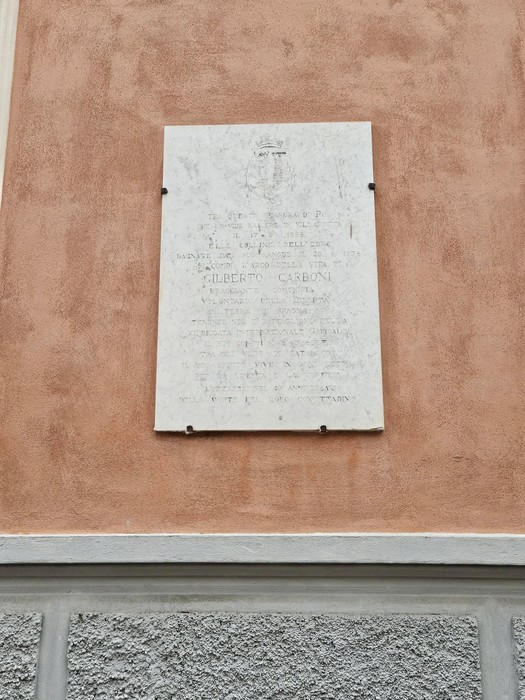 Lapide commemorativa su muro, dedicata a Gilberto Gaboni, con dettagli incisi su fondo chiaro.