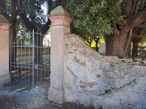 Monumento ai caduti di Pontasserchio, delimitato da una cancellata e immerso in un contesto naturale, tra alberi.