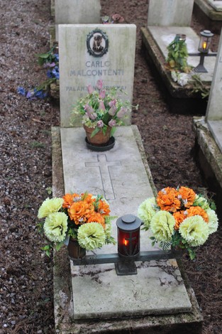 Tombe perpetue decorate con fiori e candele, commemorando i caduti per la Libertà.