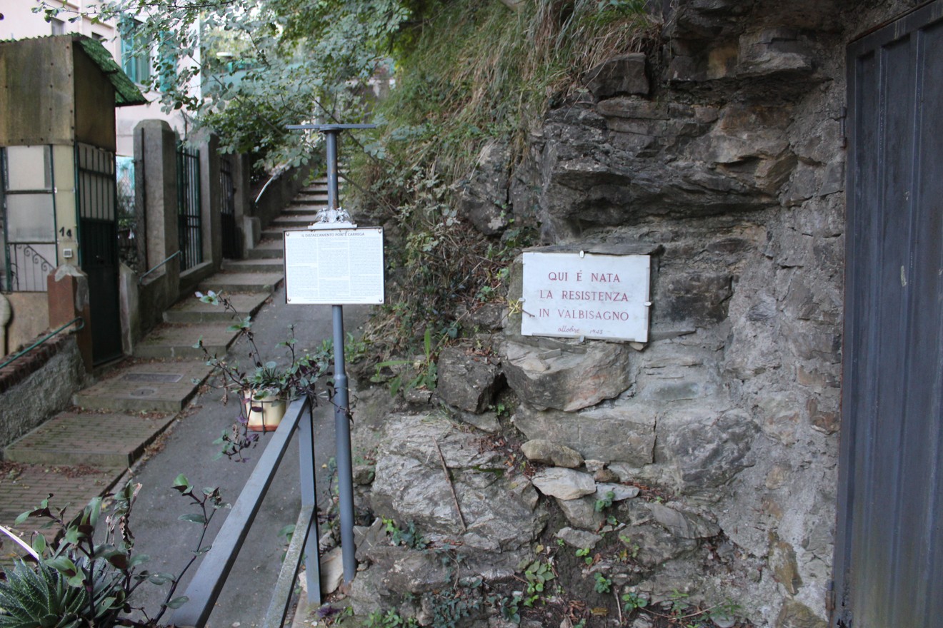 Lapide commemorativa della Brigata Guglielmetti, situata in un ambiente naturale e storico.