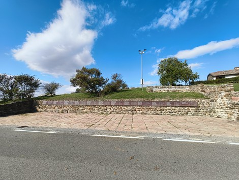 Monumento commemorativo ai partigiani caduti, situato a Monte Sabbiuno, circondato da un paesaggio verde.