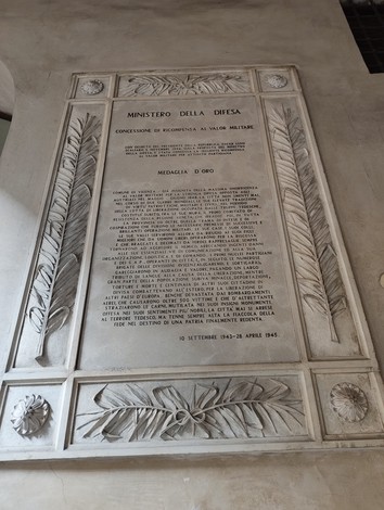 Lapide commemorativa con incisa la medaglia d'oro al valor militare, dedicata ai caduti.