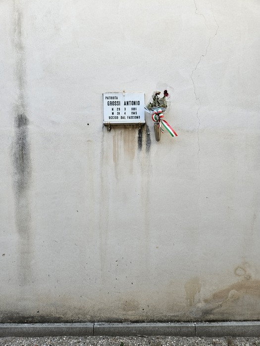 Lapide commemorativa dedicata a Grossi Antonio, con decorazioni e il tricolore italiano.