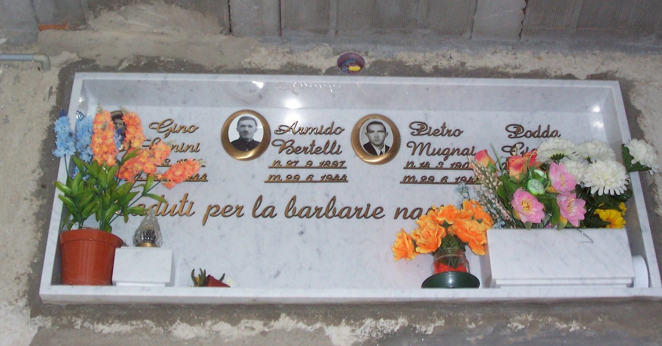 Ossario di Cetica: monumento commemorativo con targhe per i caduti, adornato da fiori e messaggi di ricordo.