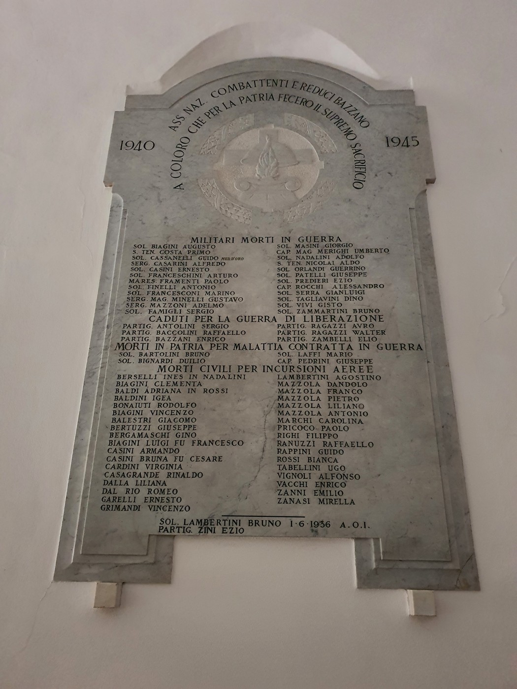 Lapide commemorativa ai caduti di Bazzano, con nomi di militari e civili morti in guerra e durante la liberazione.